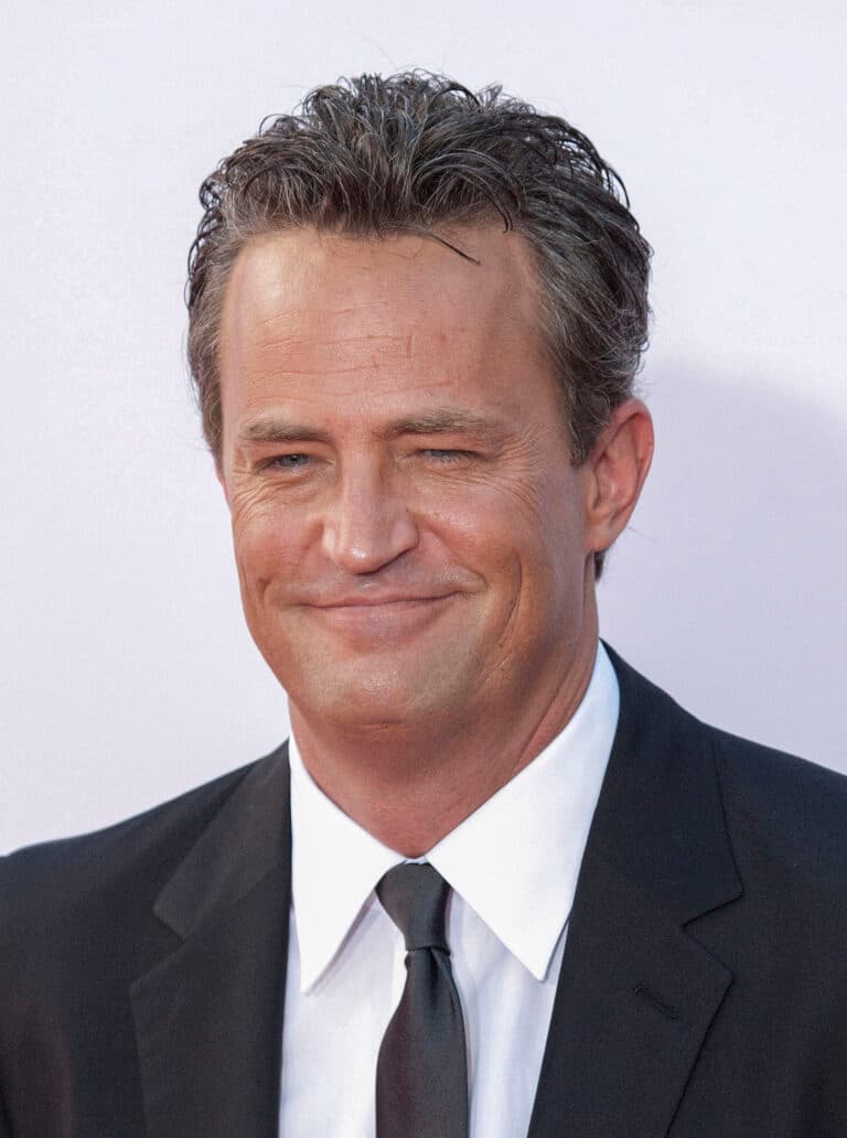 Matthew Perry sorrindo enquanto vestia um terno