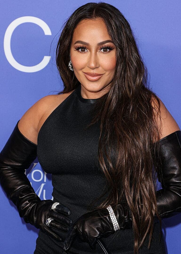Adrienne Bailon-Houghton posing on the red carpet.