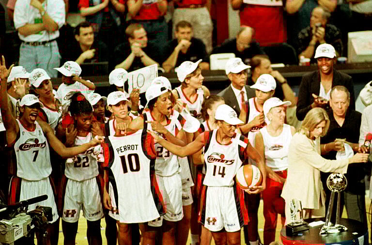 Houston Comets Cynthia Cooper and Tina Thompson hold the jersry of teammate Kim Perrot who died of cancer this year.