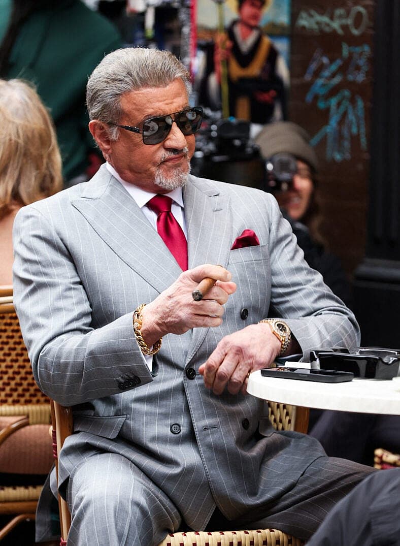 Sylvester Stallone is seen smoking a cigar as he films scenes for his show Tulsa King this morning in New York City