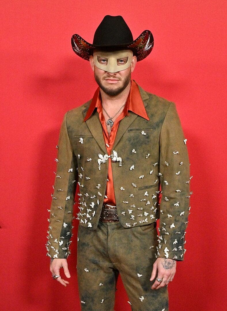 Orville Peck posing on the red carpet. 