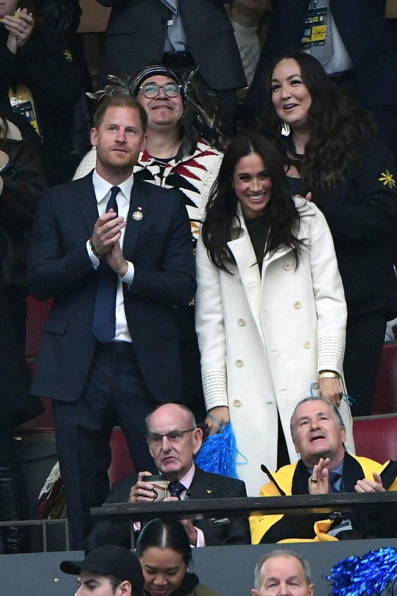 Meghan Markle and Prince Harry smiling and dancing at the Invictus Games opening ceremony