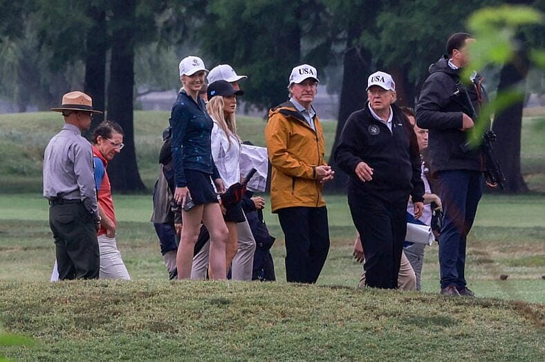 United States Secretary of the Interior and Chair, National Energy Council and White House Energy Czar Doug Burgum, center left, and US President Donald J Trump at East Potomac Golf Links in Washington, DC, US