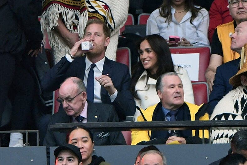Meghan Markle and Prince Harry smiling and dancing at the Invictus Games opening ceremony