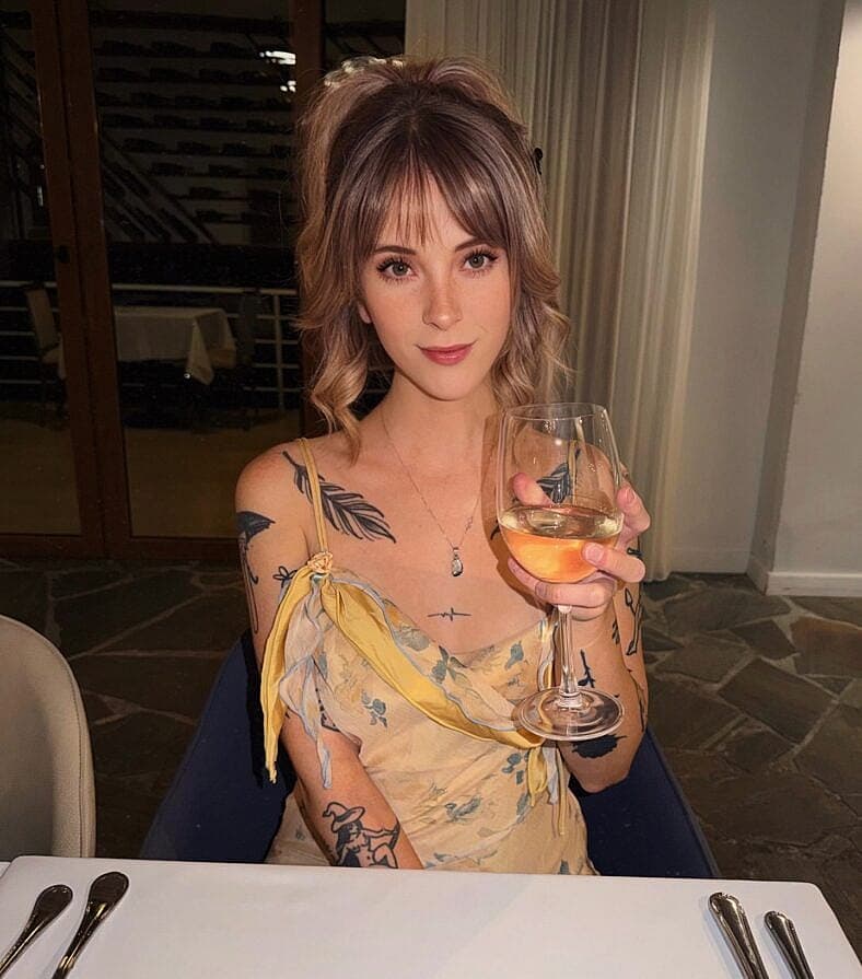Jade Vow holding a wine glass
