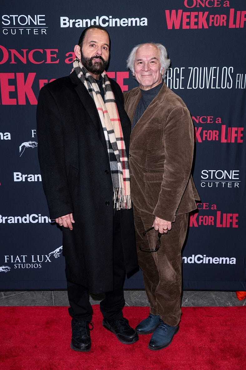 Two men standing on the red carpet.