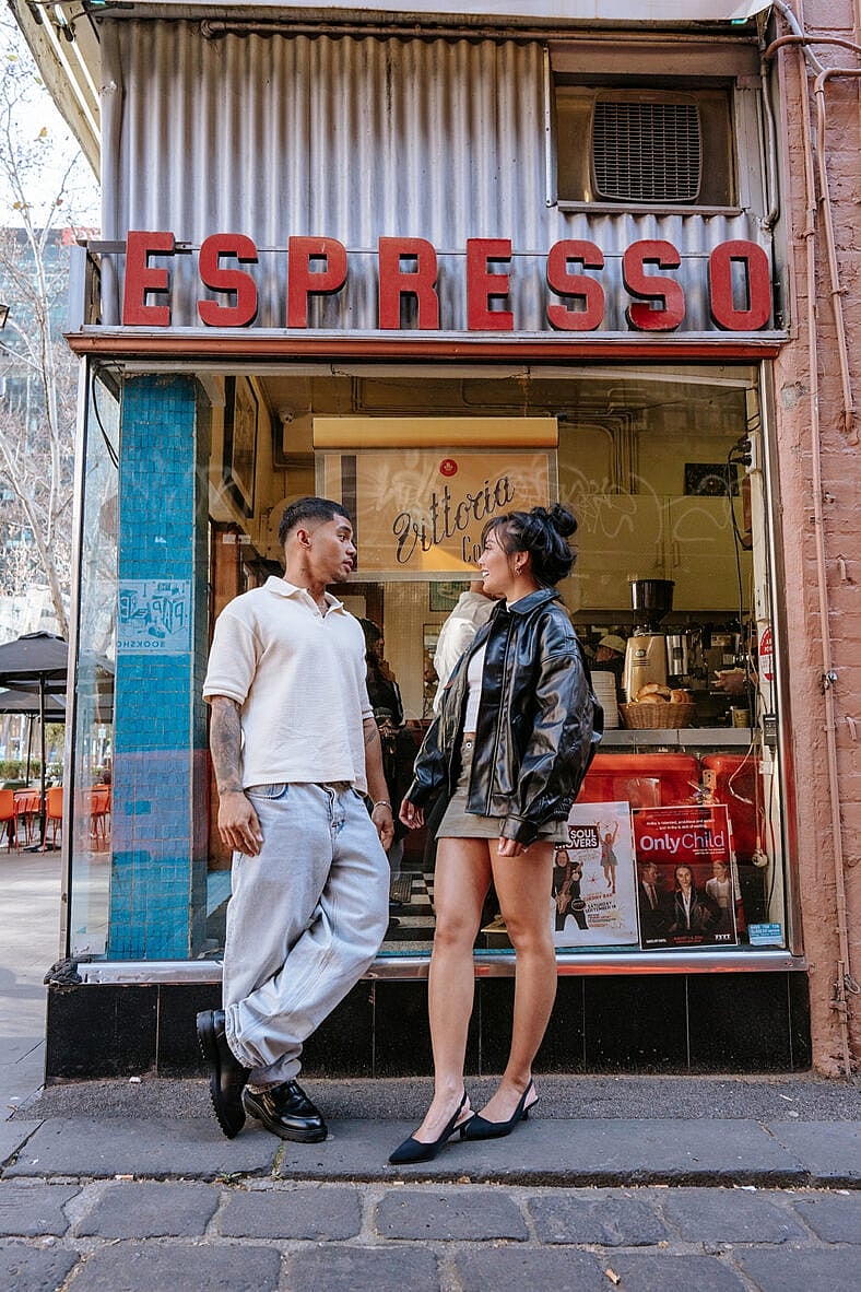 Man and woman standing in front of an espresso shop. 