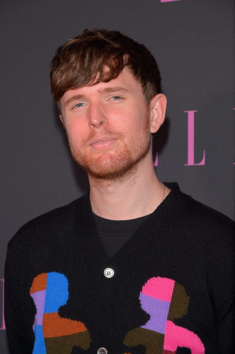James Blake posando no tapete vermelho.