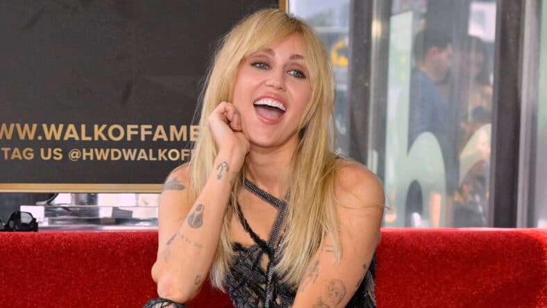 Miley Cyrus posing on the Hollywood Walk of Fame.