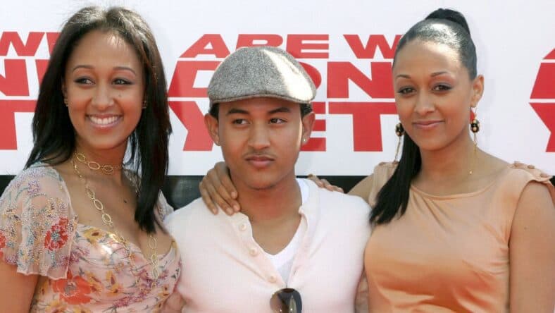 Tahj Mowry posing with sisters Tia and Tamera Mowry.