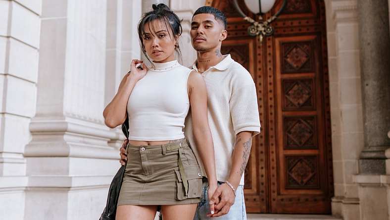 Man and woman holding hands posing for the camera.