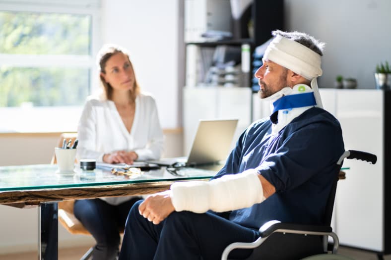 Man with cast on his arm and bandage on his head.