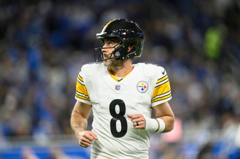 Aaron Rodgers posando no tapete vermelho.