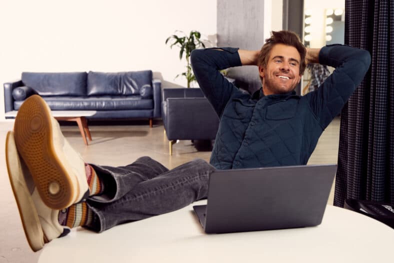 Garrett Patten smiling next to a laptop