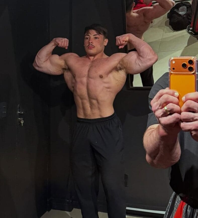 Gabriel Ganley flexionando na frente de um espelho