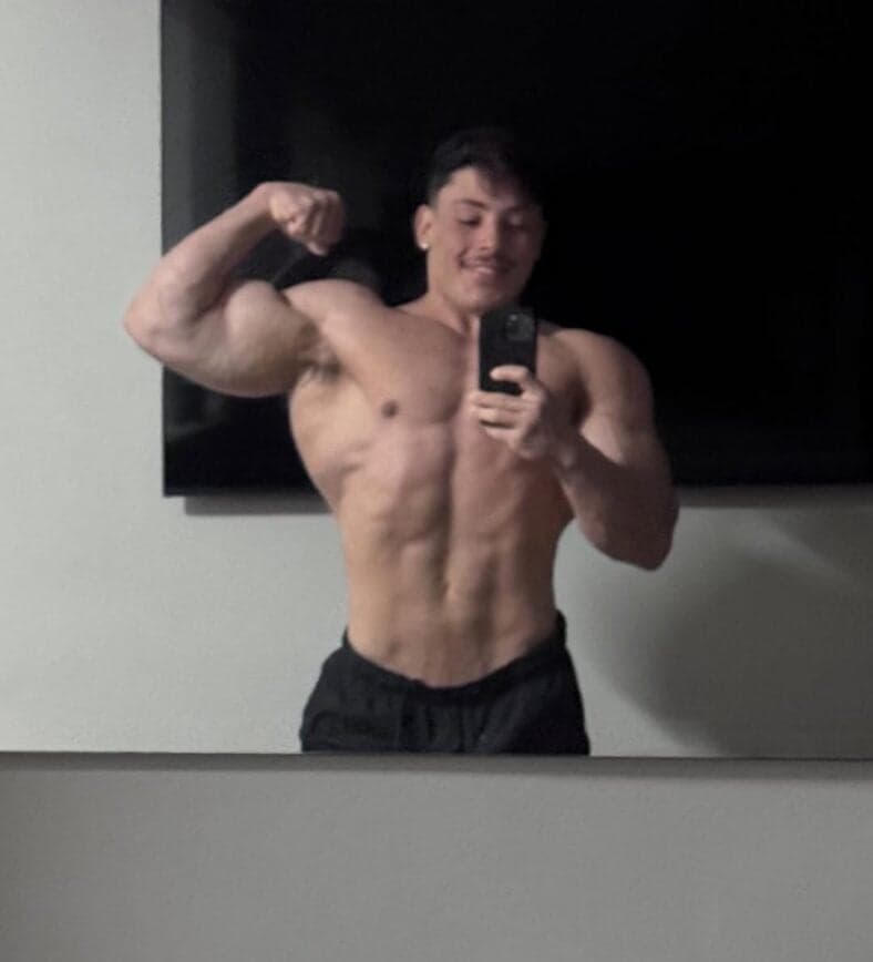 Gabriel Ganley flexing in front of a mirror