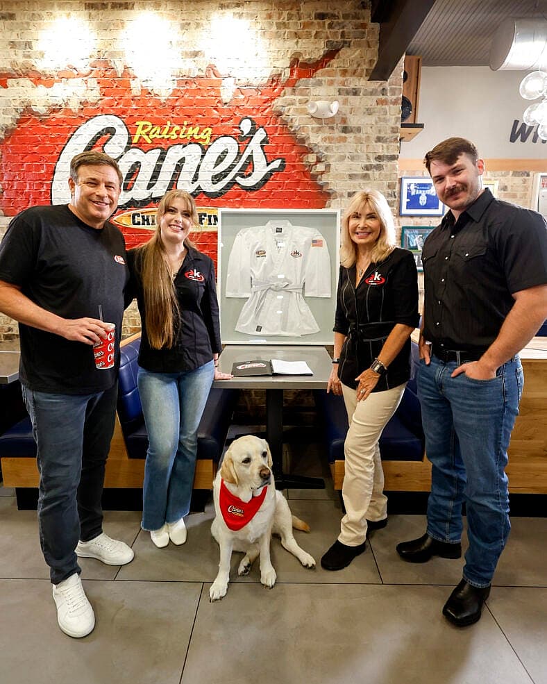 Chuck Norris' family, Todd Graves, posing in front of a gi gifted by Chuck Norris