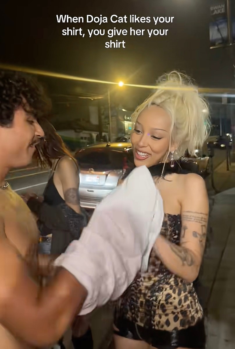 Pablo handing Doja Cat a shirt