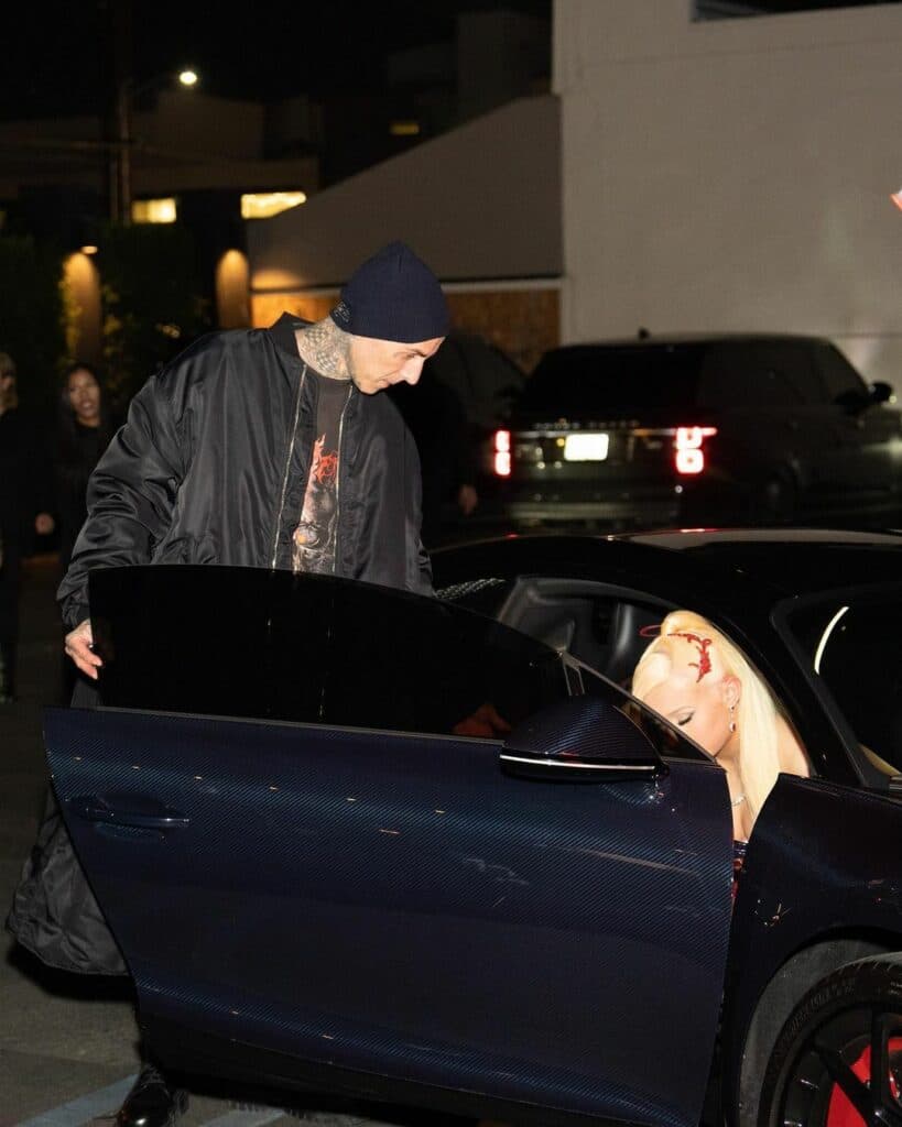 Travis Barker helping Alabama Barker out of the car.