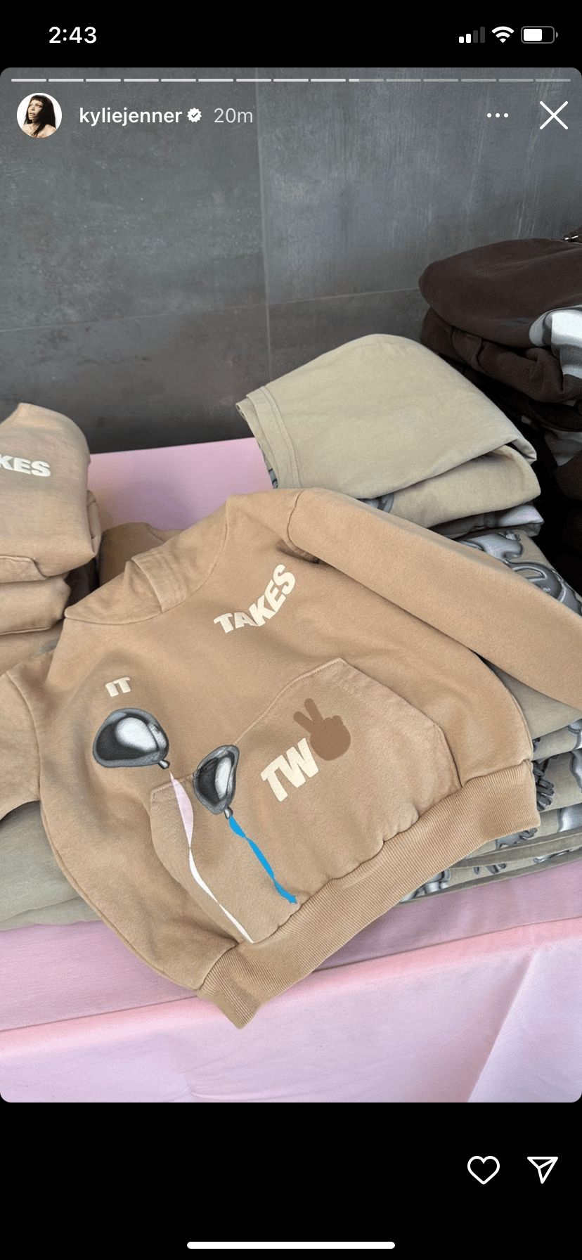 Beige and cream-colored hoodies with "TAKES" branding displayed on pink bedding