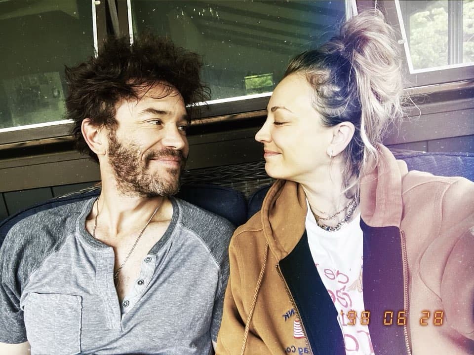Two people sitting together in a vehicle, smiling at each other