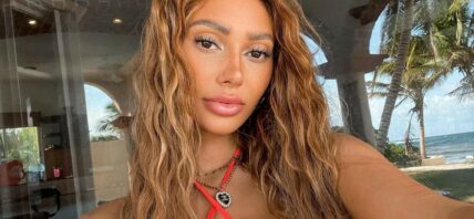 Francesca Farago taking a selfie in a red bikini top.