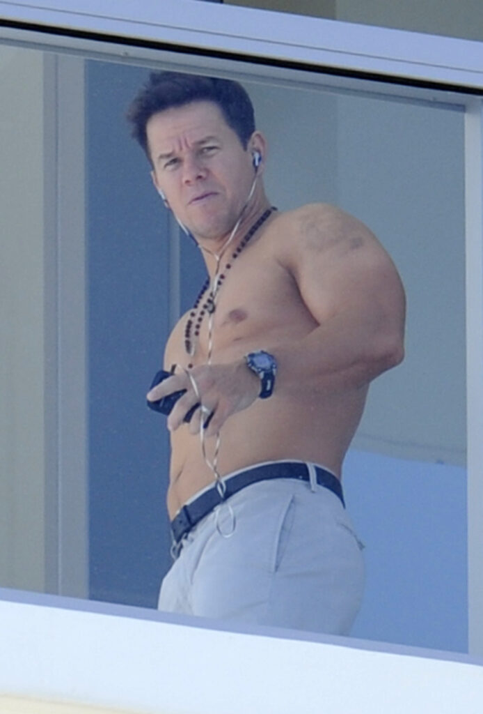 Mark Wahlberg shows off his muscles while waving shirtless from his South Beach hotel balcony