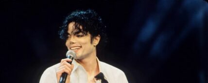 A photo showing Michael Jackson on stage in a white T-shirt.
