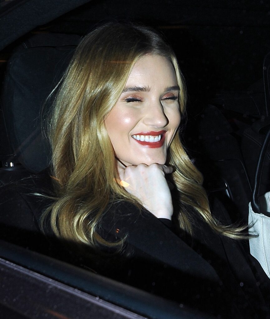 Rosie Huntington-Whiteley pokes her tongue out at snappers as she leaves Harvey Nichols department store wearing an all black outfit for her Hourglass beauty launch party