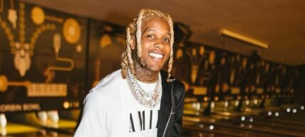 A photo showing Lil Durk smiling at the camera at an event.