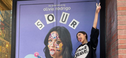 Olivia Rodrigo posing in front of 'Sour' door