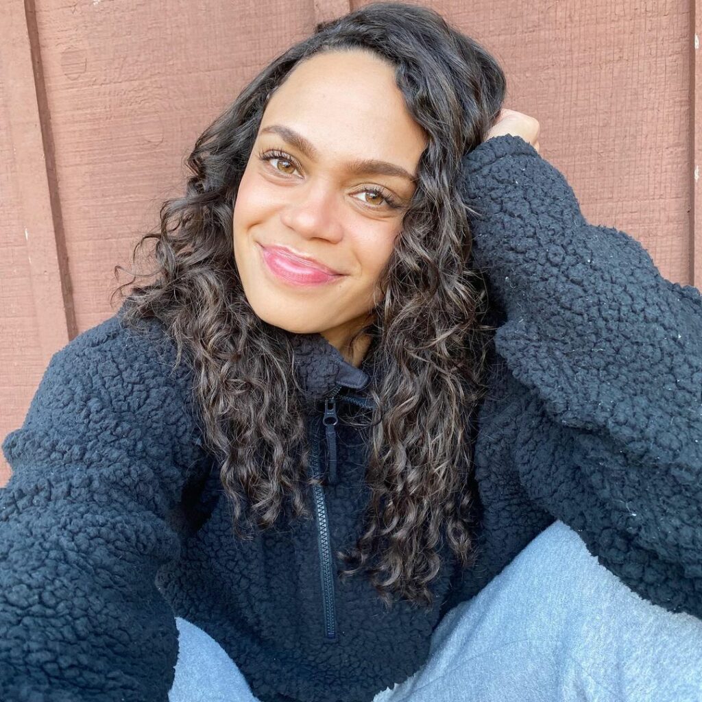 A lovely selfie photo showing Michelle Young in a blue-black sweater and denim pant.