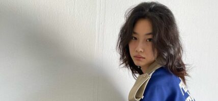A photo showing HoYeon Jung in a blue and brown color outfit.