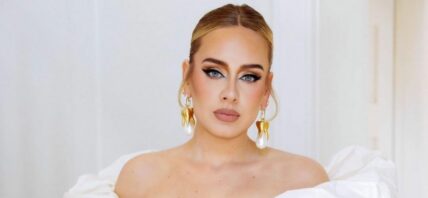 A photo showing Adele in a white off-shoulder dress.