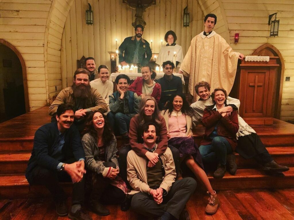 The cast of Midnight Mass gathers in the church film set for a group photo.