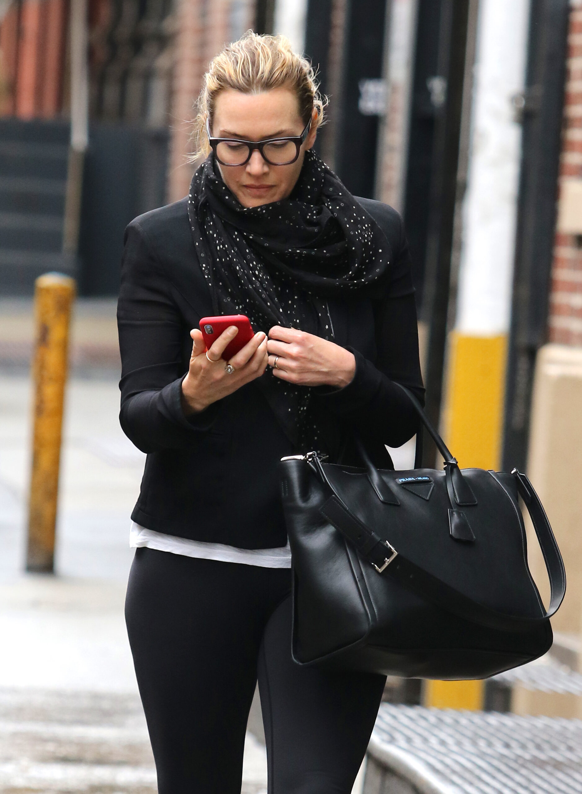 A make-up free Kate Winslet smiles for the camera while on the phone on a rainy day in NYC