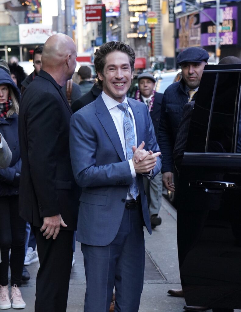 Joel Osteen outside a car