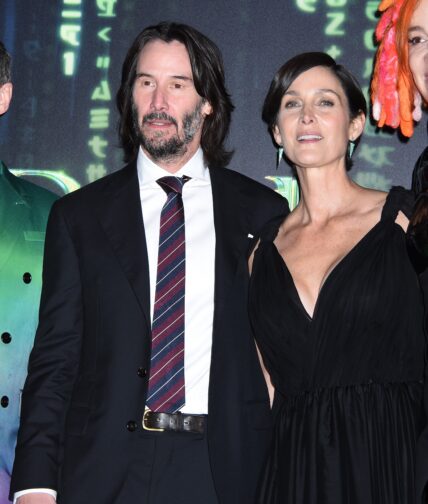 Keanu Reeves and Carrie-Anne Moss posing for the camera.