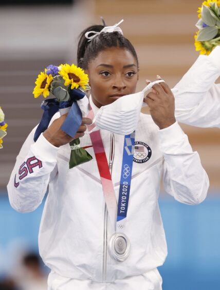 Simone Biles of the United States puts on a mask for protection against the coronavirus after photo shoots during the medal ceremony of the Tokyo Olympic women's artistic gymnastics team competition on July 27, 2021, at Ariake Gymnastics Centre. The United States took silver. (Kyodo)==Kyodo Newscom/(Mega Agency TagID: kyodowc295990.jpg) [Photo via Mega Agency]