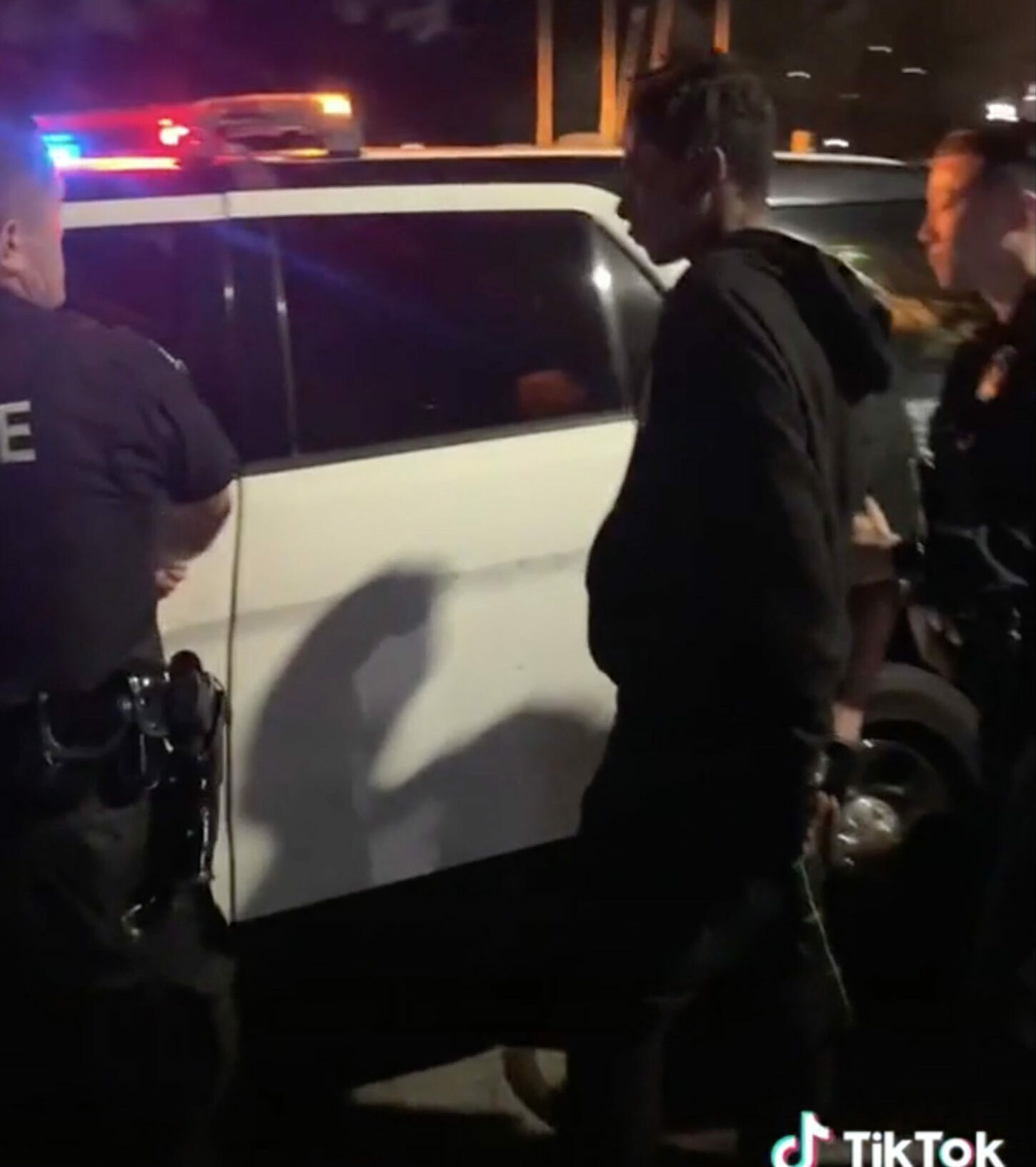 Dave Chappelle s attacker Isaiah Lee standing in handcuffs as he gets into a police car
