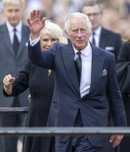 King Charles III and Queen Consort Camilla look at floral tributes left for Queen Elizabeth II outside Buckingham Palace in central London