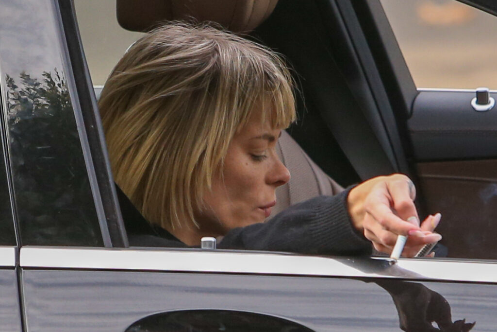 Jaime King puffs on a cigarette before walking arm in arm with a friend on Melrose Place in West Hollywood CA