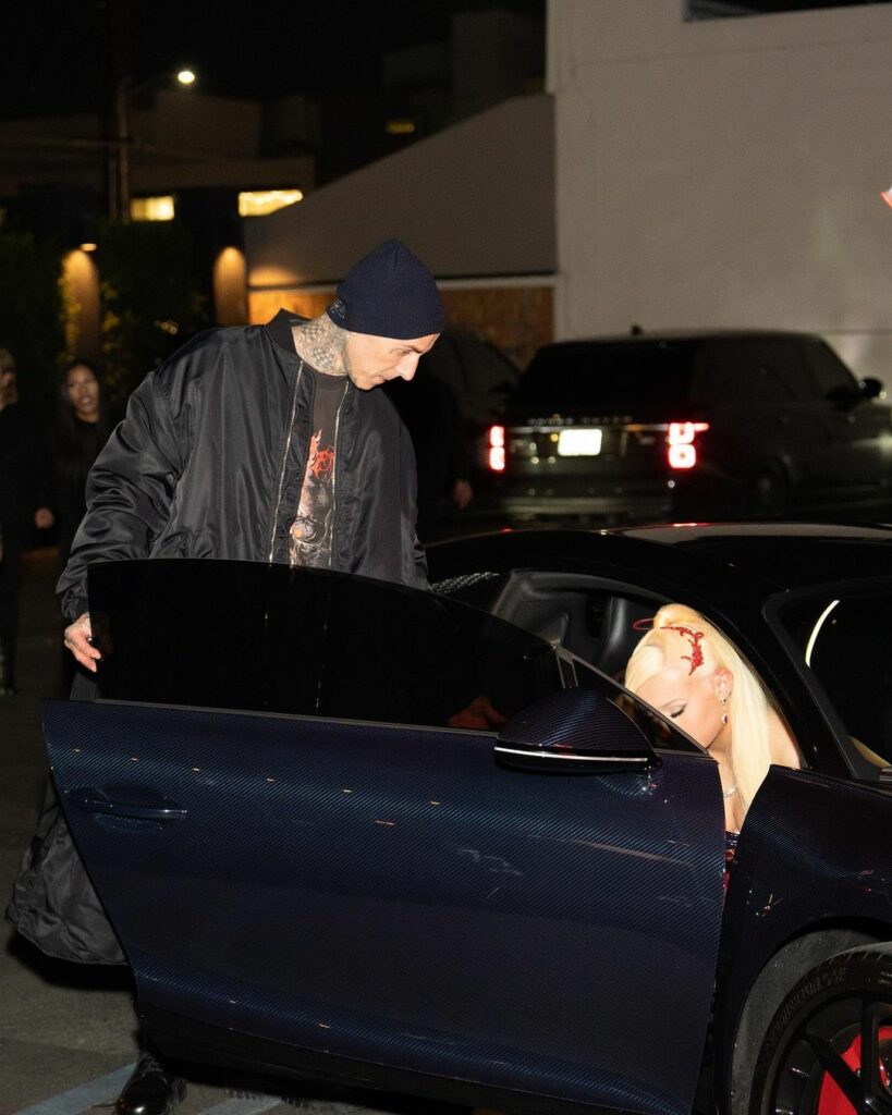 Travis Barker helping Alabama Barker out of the car.