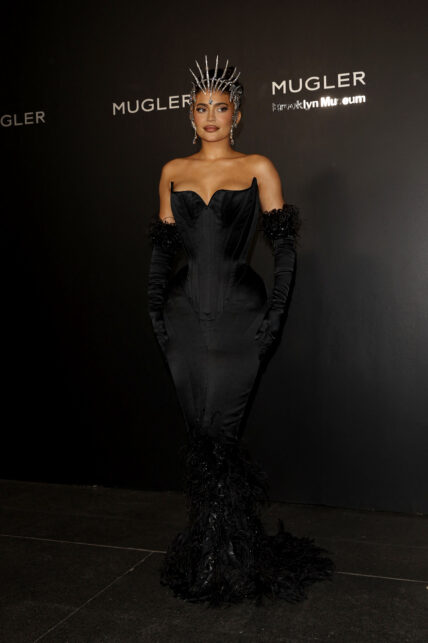 Kylie Jenner can barely walk wearing a one of a kind skin tight apos Mugler apos dress to the exhibition opening in New York City