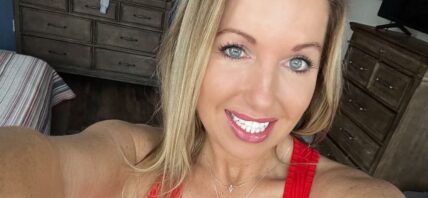 Courtney Ann in a red tank top and jeans