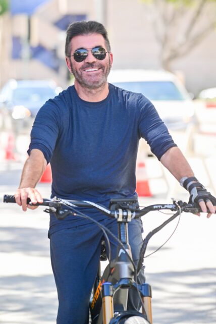 Fearless Simon Cowell hops back on a bike while still wearing a hand brace from a biking accident to film scenes for America apos s Go Talent