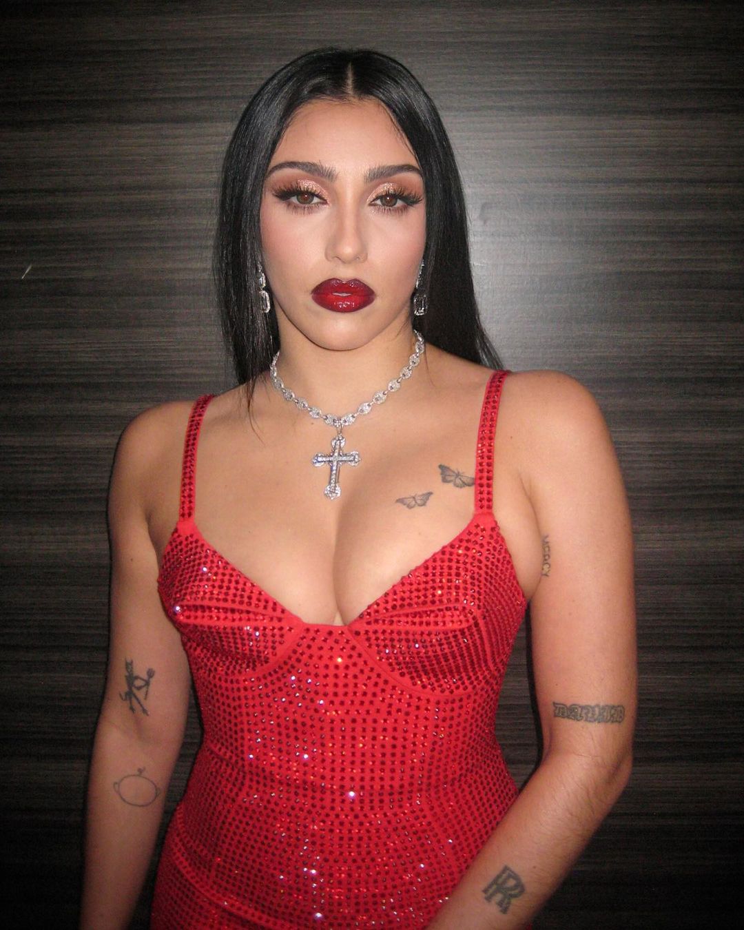 Lourdes Leon posing for the camera in a red dress.