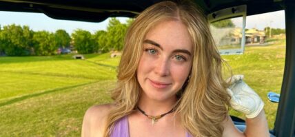 Grace Charis sits in a golf cart in a plunging purple crop top