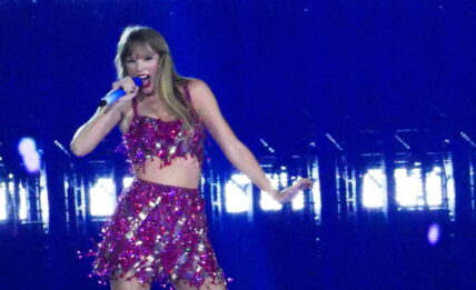 Taylor Swift holds a light saber style prop as bicycles and cars go by her in amazing visual show on stage during first weekend of her tour in Arizona