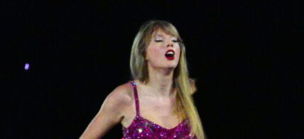 Taylor Swift holds a light saber style prop as bicycles and cars go by her in amazing visual show on stage during first weekend of her tour in Arizona